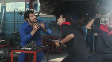 Profesyonel işçi ekipleri, çok ırklı mühendisler ve makine işçileri, garaj istasyonunda birlikte araba süspansiyonlarını tamir etmek ve sürdürmek ve otomotiv sektöründe hizmet işleri yapmak için işbirliği yapıyorlar..