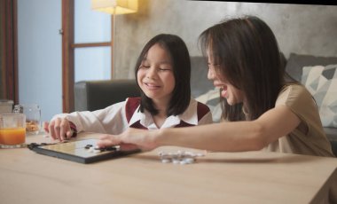 Asyalı aile, anne ve çocuk oyun oynuyorlar Go, dama masasında oyun oynuyorlar sevgi ve neşe dolu, çocuk ve ebeveynin rahatlatıcı hobisi, konsantre olup rekabet ediyorlar..