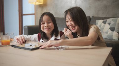 Asyalı aile, anne ve çocuk oyun oynuyorlar Go, dama masasında oyun oynuyorlar sevgi ve neşe dolu, çocuk ve ebeveynin rahatlatıcı hobisi, konsantre olup rekabet ediyorlar..