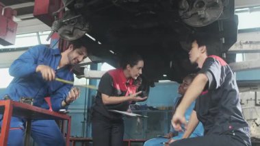 Profesyonel işçi ekipleri, çok ırklı mühendisler ve makine işçileri, garaj istasyonunda birlikte araba süspansiyonlarını tamir etmek ve sürdürmek ve otomotiv sektöründe hizmet işleri yapmak için işbirliği yapıyorlar..