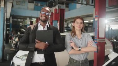 Siyah erkek sigorta acentesi ve beyaz bayan müşteri portresi, mutlu gülümseme, kolları bağlı ve neşeli, müşteri hizmetleri iş talebi, araba tamiri garantisi ve otomotiv garında bakım.