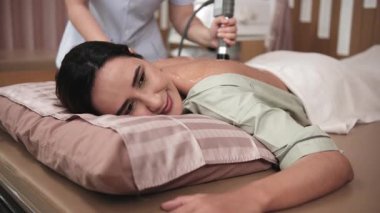 Kadın bir Latin hasta sırt ağrısı önleyici için jel ultrason cihazı ile tedavi edildi. Fiziki kas doktoru, kaplıca kliniğinde pasif tıbbi terapi ve sağlık hizmetleri mesajlaşması..