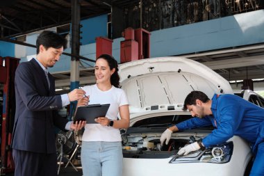 Garanti hizmeti işi, Latin kadın müşteri, Asyalı erkek sigorta acentesinden neşeli sözleşme belgesi, kazadan kalma arabayı kabul etme, otomotiv garajında tamirci..