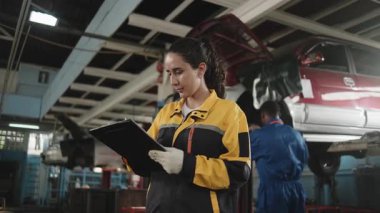 İspanyol kadın tamirci müfettişi, bir tamirhanenin bakım işlerinde yedek parça listesi, otomotiv ve ulaşım sektöründe profesyonel mühendis işleri..
