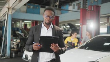 Siyahi sigorta acentesinin gülümseyen, kollarını kavuşturan, neşeli ve kameraya bakan portresi müşteri hizmetleri, garaj otomotiv sektöründe araba tamiri ve bakım..