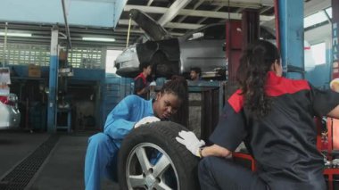 Kadın tamirciler araba tekerleklerini tamir etmeyi, garaj istasyonunda çok ırklı otomotiv bakım ekiplerini ve araç taşımacılığı sektöründe teknisyen mühendisliği hizmetlerini tartıştılar..