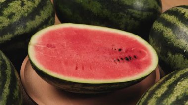 Tahta bir tabakta yarım parça taze kırmızı karpuz, tropikal tatlı ve besleyici atıştırmalıklar ve bol meyveli sağlıklı yiyecekler..