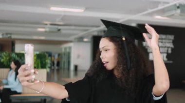 Akademik elbise içinde genç bir Siyahi genç öğrenci, mutluluk selfie 'si ve kampüste dönüm noktasında cep telefonuyla video görüşmesi, üniversite sertifikasında neşeli bir kutlama, diploma derecesi.