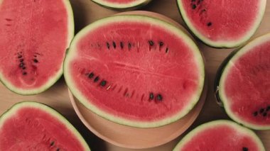 Tahta bir tabakta yarım parça taze kırmızı karpuz, tropikal tatlı ve besleyici atıştırmalıklar ve bol meyveli sağlıklı yiyecekler..