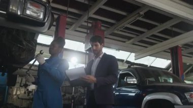 Latin erkek işletme müdürü Siyah Mekanik Kadın, araba süspansiyonu düzeltme talepleri kontrol listesi ve sigorta garantisi, otomotiv garajında mekanik bakım ve ulaşım endüstrisi konularını görüştü.