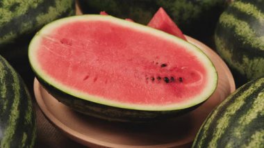 Tahta bir tabakta yarım parça taze kırmızı karpuz, tropikal tatlı ve besleyici atıştırmalıklar ve bol meyveli sağlıklı yiyecekler..