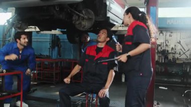 Profesyonel işçi ekipleri, çok ırklı mühendisler ve makine işçileri, garaj istasyonunda birlikte araba süspansiyonlarını tamir etmek ve sürdürmek ve otomotiv sektöründe hizmet işleri yapmak için işbirliği yapıyorlar..