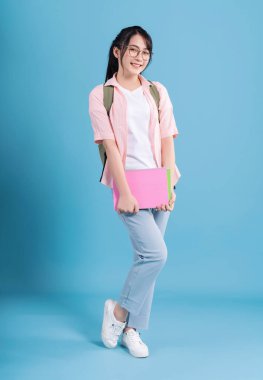 Mavi arka planda genç Asyalı öğrenci