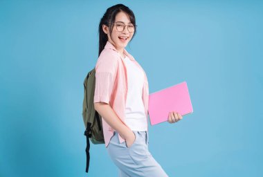 Mavi arka planda genç Asyalı öğrenci