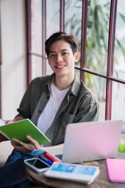 Genç Asyalı işadamı kahve dükkanında çalışıyor.