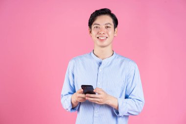 Arka planda akıllı telefon kullanan Asyalı genç adamın fotoğrafı