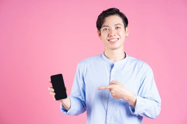 Arka planda akıllı telefon kullanan Asyalı genç adamın fotoğrafı