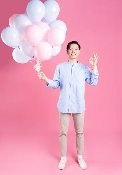 Молодой Азиат Держит Воздушный Шар Розовом Фоне — стоковое фото