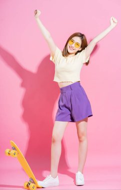 Pembe arka planda kaykaylı Asyalı genç kızın fotoğrafı.