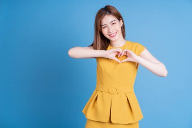 Mavi arka planda poz veren genç Asyalı kadın portresi