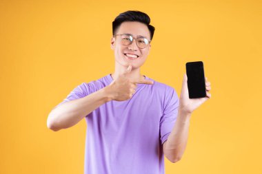 Arka planda akıllı telefon kullanan Asyalı genç bir adamın görüntüsü