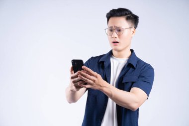 Genç Asyalı adam arka planda akıllı telefon kullanıyor.