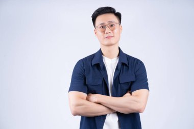 Beyaz arka planda poz veren Asyalı bir genç resmi