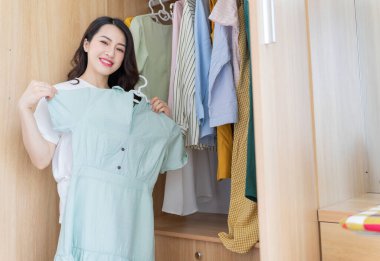 Genç Asyalı kadın elbise deniyor.