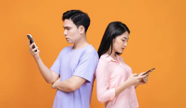 Arka planda akıllı telefon kullanan genç Asyalı çift