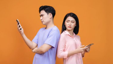 Arka planda akıllı telefon kullanan genç Asyalı çift