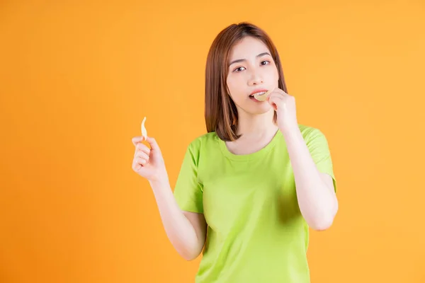 stock image Photo of young Asian girl eating snack on background