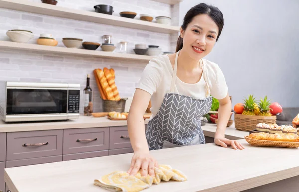 Young Asian woman cleaning the kitchen after cooking
