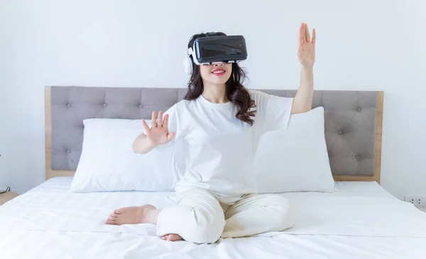 stock image Young Asian woman using virtual reality glasses at home