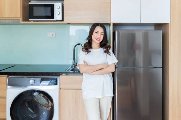 Image of young Asian woman with fridge