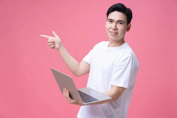 若いアジア人男性保持ノートパソコン上の背景 — ストック写真