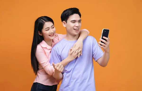 年轻的亚洲夫妇使用智能手机为背景 — 图库照片