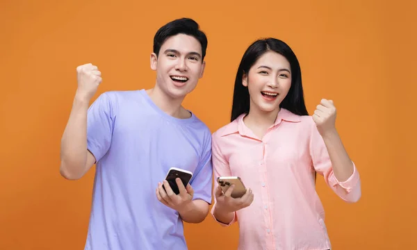 stock image Young Asian couple using smartphone on background