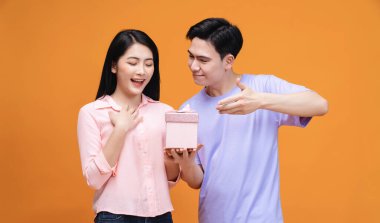 Arka planda hediye kutusu olan genç Asyalı çift.