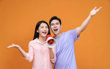 Arka planda megafonu olan genç Asyalı çift.