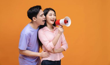 Arka planda megafonu olan genç Asyalı çift.