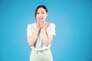 Mavi arka planda duran genç Asyalı kadın portresi