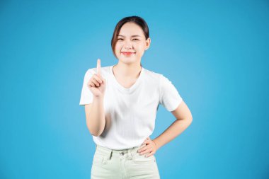 Mavi arka planda duran genç Asyalı kadın portresi