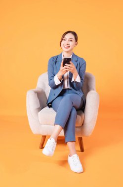 Koltukta oturan genç Asyalı iş kadınının fotoğrafı.