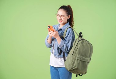 Yeşil arka planda genç bir Asyalı üniversiteli kızın fotoğrafı