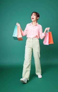 Arka planda alışveriş torbası tutan Asyalı genç bir kız resmi