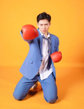 Boks eldivenli genç Asyalı kızgın iş adamının görüntüsü