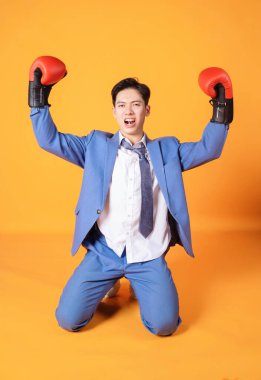 Boks eldivenli genç Asyalı kızgın iş adamının görüntüsü