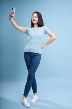 Arka planda poz veren genç Asyalı kadın