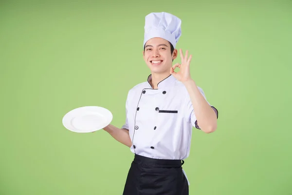 stock image Photo of young Asian male chef on background