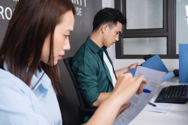 Ofiste çalışan iki genç Asyalı iş adamının fotoğrafı.